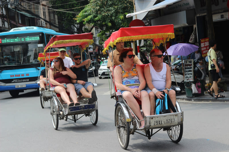 圖為旅客搭乘人力三輪車遊河內老街。圖片來源：中央社