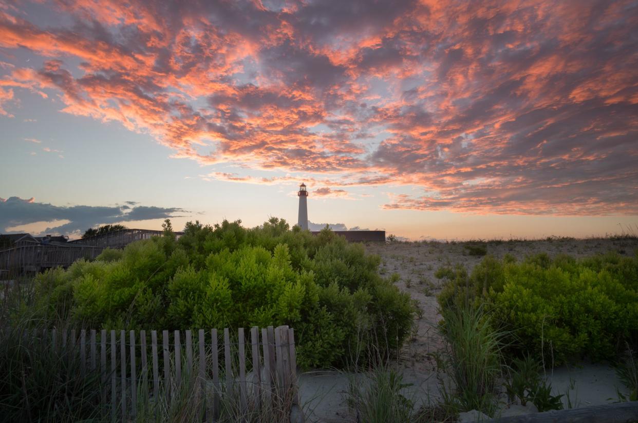 Cape May Lighthouse, Cape May Point, New Jersey during sunset, with sand dunes in the foreground