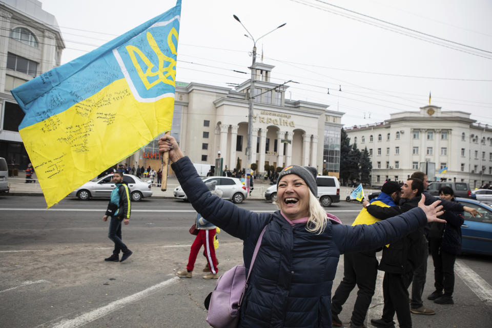 Ucranianos reunidos en el centro para celebrar que tropas ucranianas han recuperado su ciudad, Jersón, en Ucrania, el sábado 12 de noviembre de 2022. (AP Foto/Yevhenii Zavhorodnii)