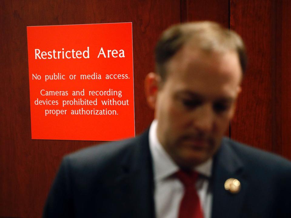 A sign marks a door to a secure area behind Rep. Lee Zeldin.