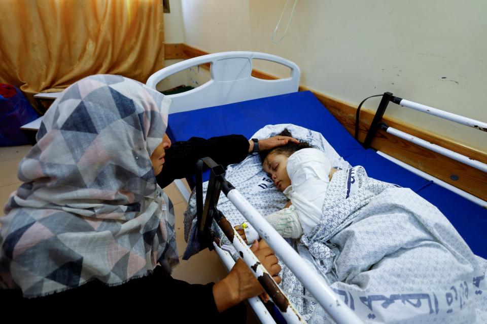 2023年10月14日，加薩南部甘尤尼斯的醫院裡，一名祖母安撫4歲女童睡覺。她們家族14人死於空襲，包含女童的父母和手足。路透社