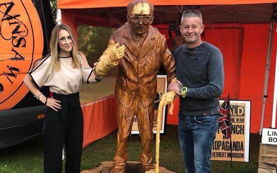 Adele Dunham and Simon Bogg with the wood carving of Captain Sir Tom Moore last year - Hannah-Jayne King /PA