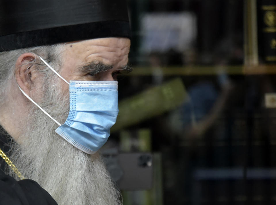 Serbian Orthodox bishop Amfilohije wearing a mask against the spread of the coronavirus prepares to vote in parliamentary elections at a polling station in Cetinje, Montenegro, Sunday, Aug. 30, 2020. Voters in Montenegro on Sunday cast ballots in a tense election that is pitting the long-ruling pro-Western party against the opposition seeking closer ties with Serbia and Russia. (AP Photo/Risto Bozovic)