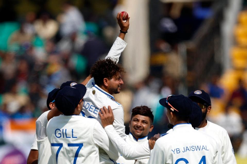 Celebration: India spinner Kuldeep Yadav is mobbed by team-mates after his five-wicket haul against England (REUTERS)