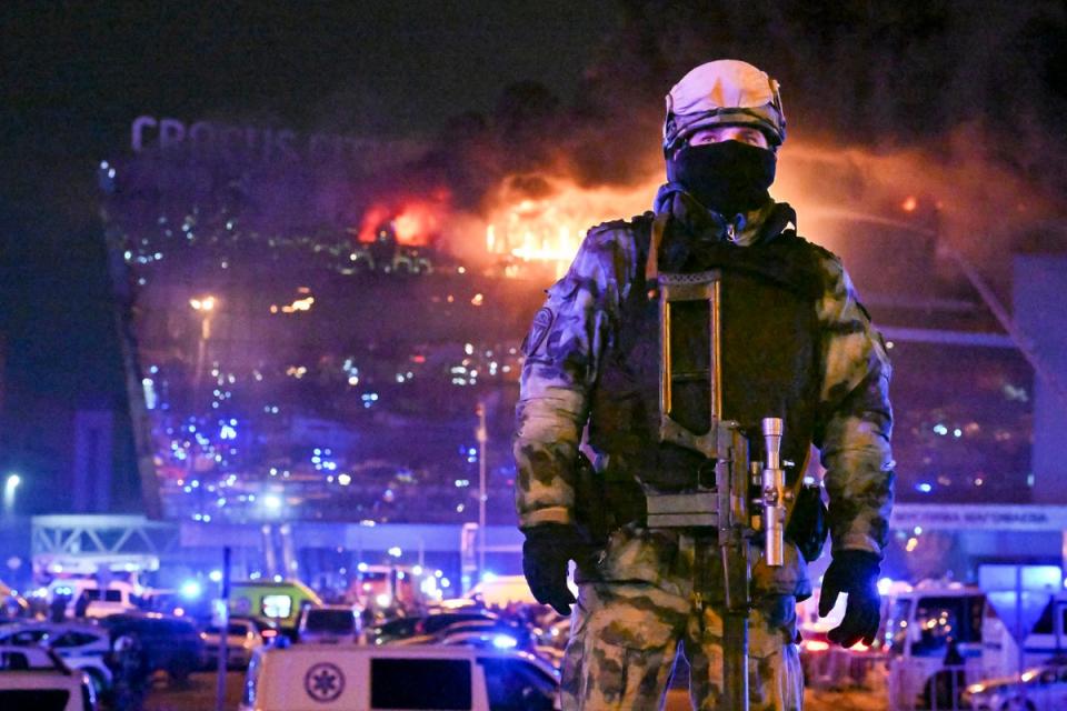 A Russian Rosguardia (National Guard) servicemen secures an area as a massive blaze seen over the Crocus City Hall on the western edge of Moscow, Russia, Friday, 22 March 2024 (AP)