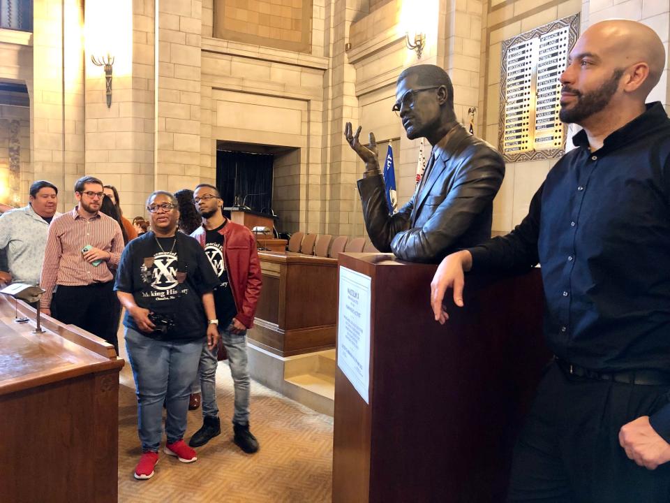  Nathan Murray, at right, the Lincoln artist who created the bust of Malcom X, talks to people as they line up to get a photo with the bust. (Cindy Gonzalez/Nebraska Examiner)