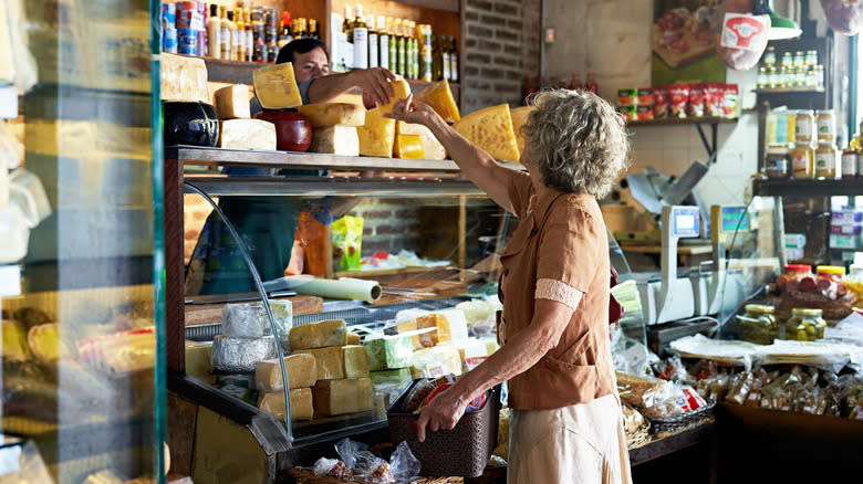 Woman buying cheese at specialty shop