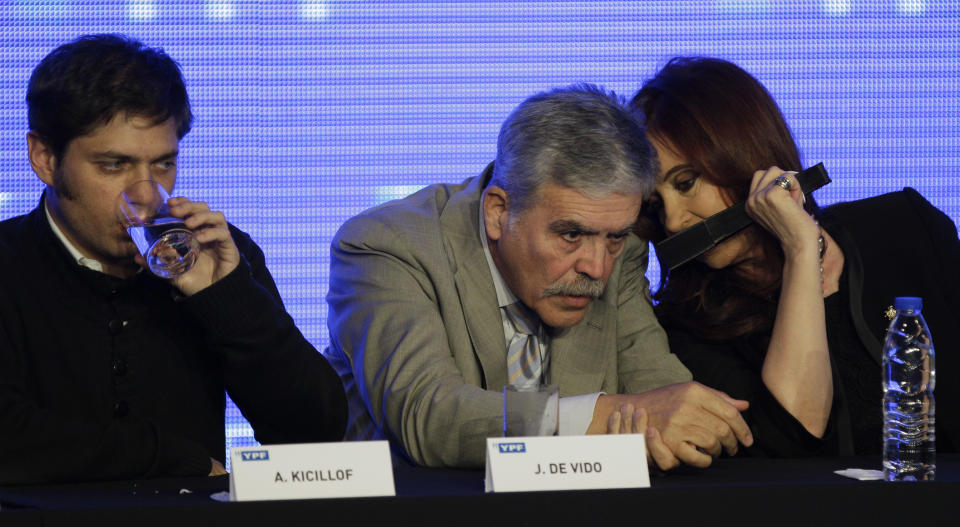 Argentina's President Cristina Fernandez, right, talks to Planning Minister Julio De Vido, center, as YPF oil company's Argentine state representative and Deputy Economy Minister Axel Kicillof drinks water during a ceremony to announce new investments in YPF in Buenos Aires, Argentina, Tuesday, June 5, 2012. The chief executive of the newly state-controlled Argentine energy company YPF Miguel Galuccio announced a five-year plan that includes an investment of up to $7 billion annually to expand exploration and boost production. (AP Photo/Natacha Pisarenko)