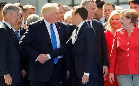Donald Trump jokes with French President Emmanuel Macron about their handshakes in front of NATO leaders - Credit: REUTERS&nbsp;