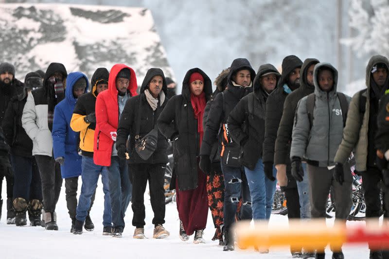 FILE PHOTO: Group of migrants arrive to the international border crossing at Salla