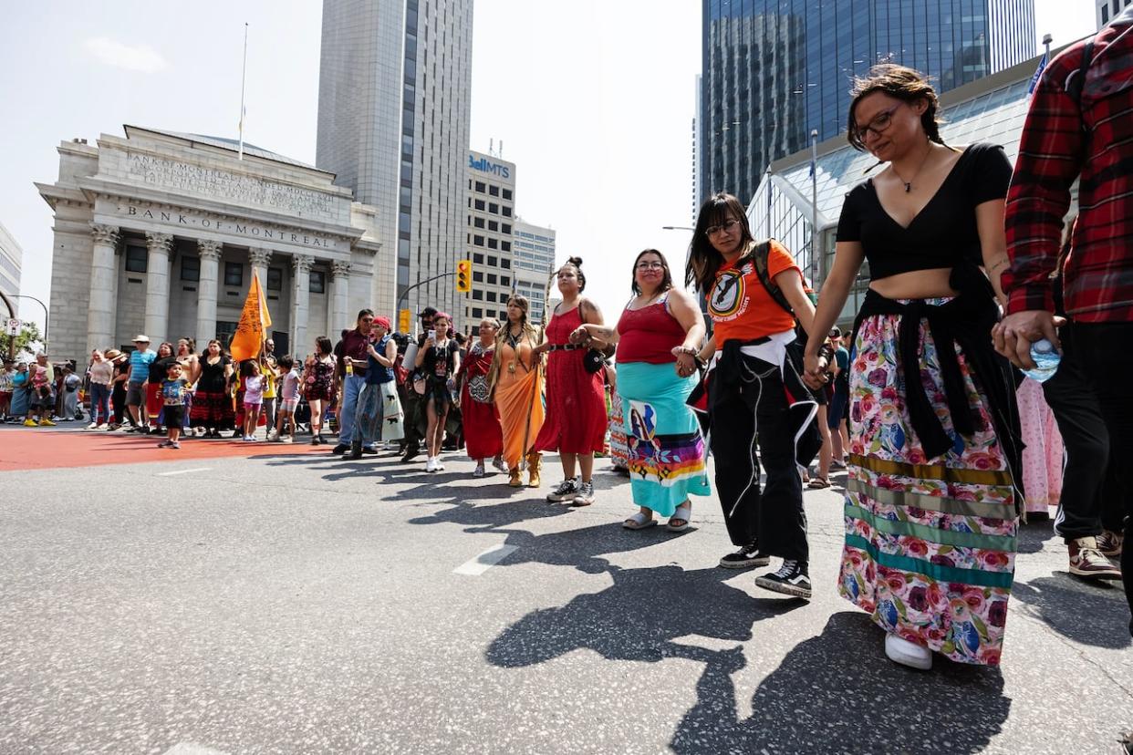 About 200 people took part in a round dance at Portage and Main on Thursday afternoon to call for a search of the privately-run Prairie Green landfill for the remains of two Indigenous women. (Prabhjot Singh Lotey/CBC - image credit)