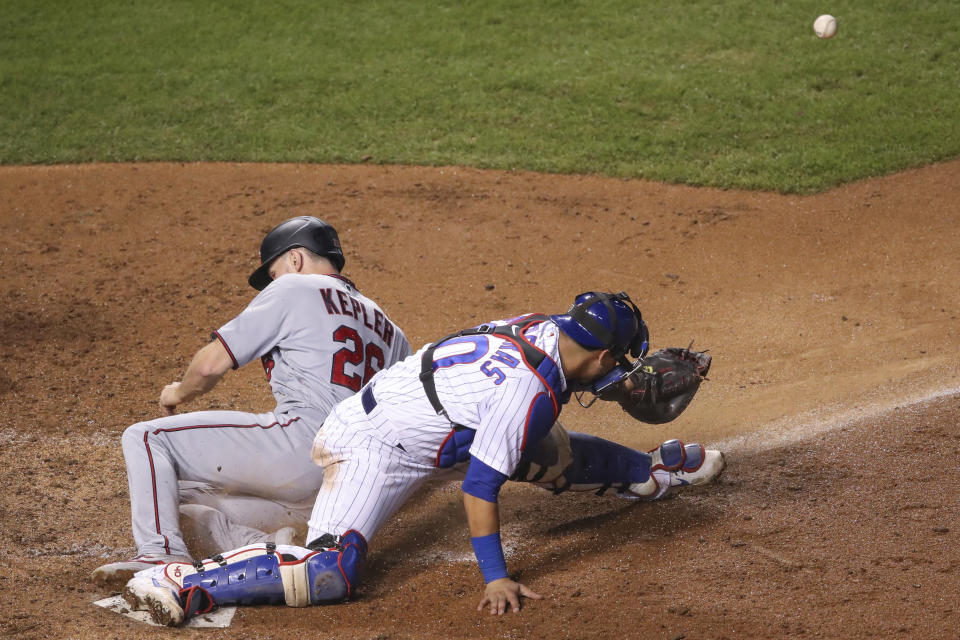 Minnesota Twins' Max Kepler, left, scores as Chicago Cubs' Willson Contreras, right, waits for the ball during the seventh inning of a baseball game, Saturday, Sept. 19, 2020, in Chicago. (AP Photo/Kamil Krzaczynski)