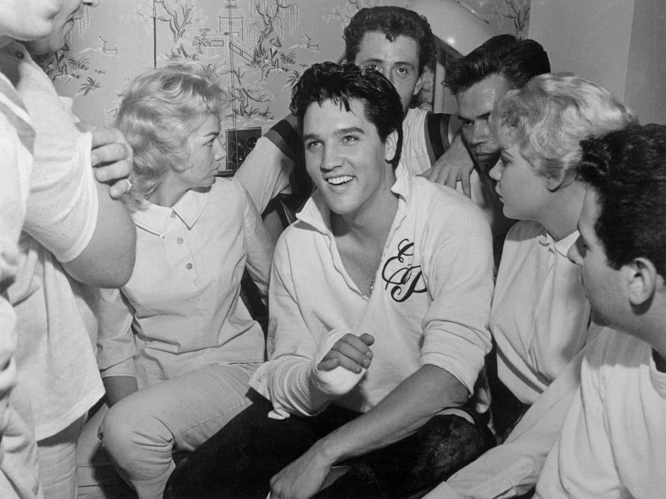 Elvis Presley in a hospital room with Anita Wood (left of him) and others in 1960.