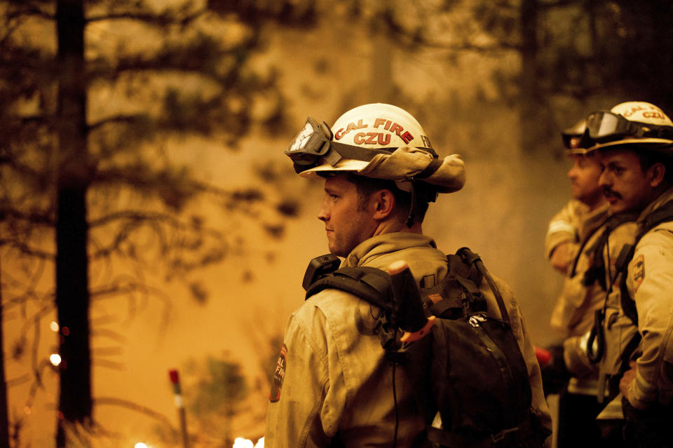 Firefighter Jesse Forbes monitors flames as his crew burns vegetation to stop the Dixie Fire from spreading near Prattville in Plumas County, Calif., on Friday, July 23, 2021. (AP Photo/Noah Berger)
