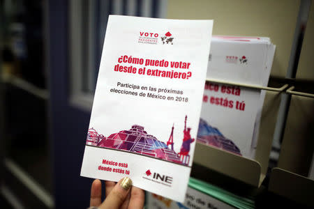 A woman holds a pamphlet encouraging Mexicans to register to vote in the Mexican Consulate in Los Angeles, California U.S. January 16, 2018. REUTERS/Lucy Nicholson