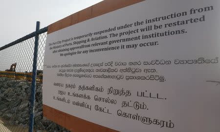 A notice sign is seen in front of the construction site of Chinese investment "Colombo Port City" in Colombo March 10, 2015. REUTERS/Dinuka Liyanawatte