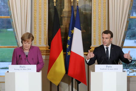 French President Emmanuel Macron (R) and German Chancellor Angela Merkel give a joint press conference at the Eylsee presidential Palace in Paris, France March 16, 2018. Ludovic Marin/Pool via REUTERS