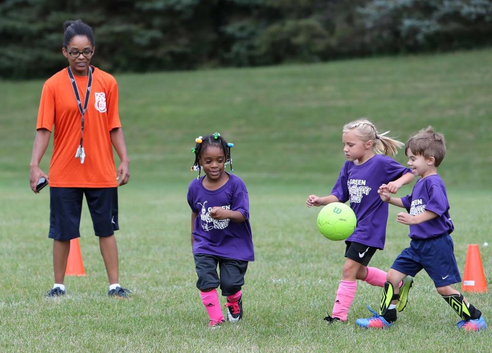 Terah Coleman, left, coaches as her daughter  Aliyah, 5, and two of her teammates go after the ball during a game  at Boettler Park in Green. 