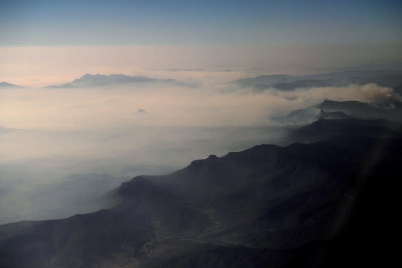 Smoke from bushfires blanket mountain ranges as seen during a commercial flight over northern New South Wales