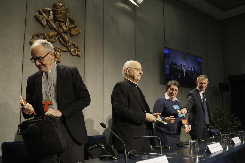 From left, Cardinal Michael Czerny, Cardinal Lorenzo Baldisseri and Sister Augusta de Oliveira hold a copy of the post-synodal apostolic exhortation "Querida Amazonia" written by Pope Francis during a press conference at the Vatican, Wednesday, Feb. 12, 2020. (AP Photo/Gregorio Borgia)