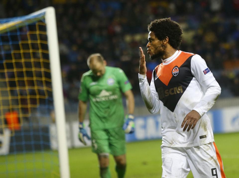 Shakhtar&#39;s Luiz Adriano celebrates after scoring against BATE as BATE&#39;s goalkeeper Sergei Chernik looks on during their Champions League Group Stage in group H soccer match in Borisov, Belarus, Tuesday, Oct. 21, 2014. (AP Photo/Sergei Grits)