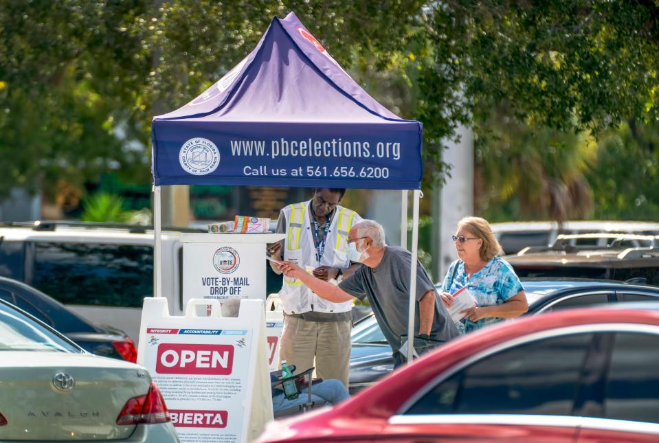 Voters deliver their vote-by-mail ballots to a drop off box at the Supervisor of Elections Main Office in West Palm Beach, Florida on October 24, 2022.