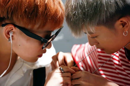 Members of China's all-girl "boyband" FFC-Acrush fix a necklace before a rehearsal at a dance studio in Beijing April 27, 2017.REUTERS/Thomas Peter