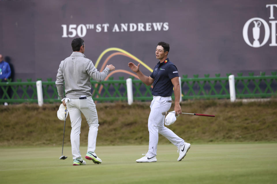 Rory McIlroy of Northern Ireland, left, and Viktor Hovland, of Norway, shake hands on the 18th green after their third round of the British Open golf championship on the Old Course at St. Andrews, Scotland, Saturday July 16, 2022. (AP Photo/Peter Morrison)