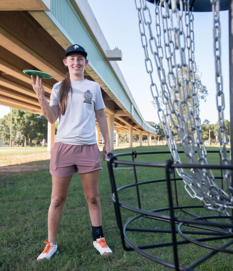 Five-time Professional Disc Golf Association World Champion Paige Pierce poses next to a basket temporarily set up at Hollice T. Williams Park along I-110 in downtown Pensacola on Monday, Oct. 2, 2023.