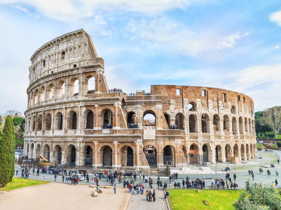 ariel shot of the coliseum in rome with tourist milling around it