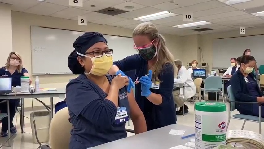 A staff nurse receives a COVID vaccination at Sarasota Memorial Hospital in December.