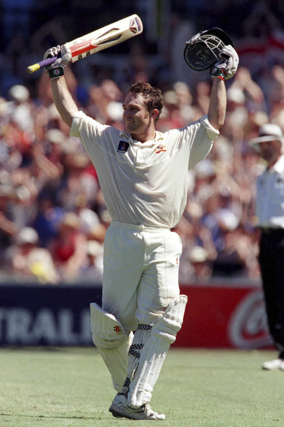 FILE - Australia Cricketer Michael Slater left, celebrates hitting a century during a test against England in this Jan. 4, 1999 file photo in Sydney, Australia. Ex-test cricketer Slater has been remanded in prison while awaiting trial on 19 charges relating to domestic violence and breaches of bail. The 54-year-old Slater was refused bail Tuesday, April 16, 2024, when he appeared in Maroochydore Magistrates Court in Queensland state charged with unlawful stalking or intimidation, breaking into a dwelling with intent at night, common assault, assault occasioning bodily harm and choking or suffocation. (AP Photo/Brendon Espesito, File)