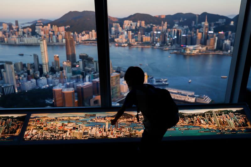 FILE PHOTO: A child plays in front of skyline buildings, in Hong Kong