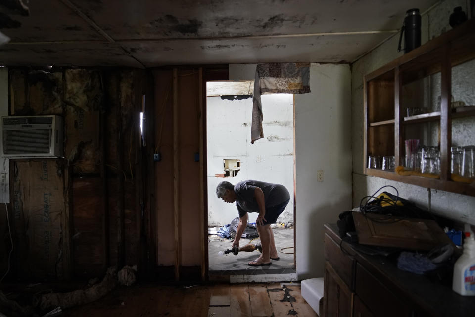Irene Verdin looks through her home that was heavily damaged by Hurricane Ida in August 2021, along Bayou Pointe-au-Chien, La., Tuesday, May 24, 2022. (AP Photo/Gerald Herbert)