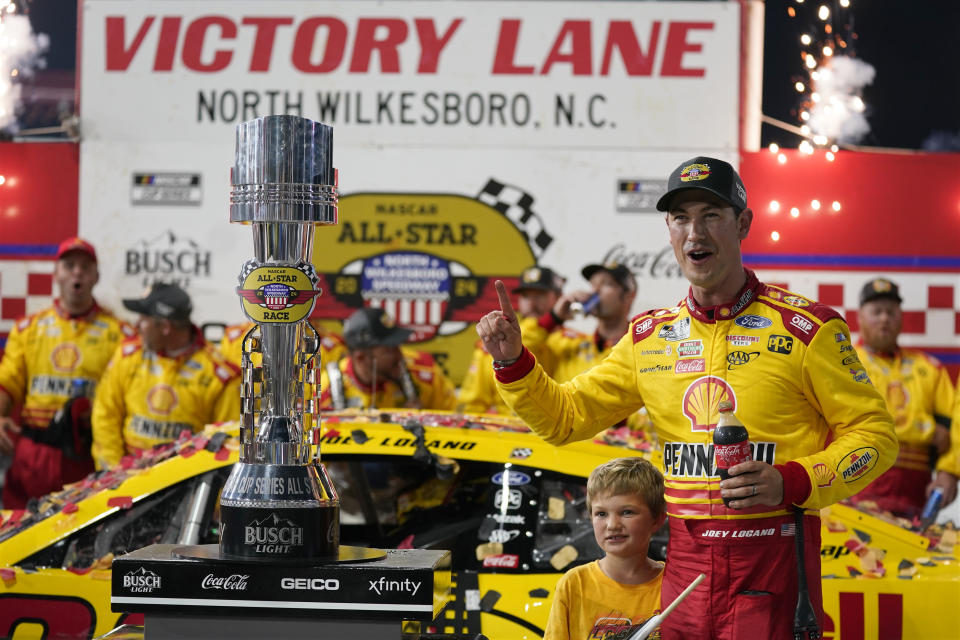 Joey Logano poses with the trophy in Victory Lane after winning the NASCAR All-Star auto race at North Wilkesboro Speedway in North Wilkesboro, N.C., Sunday, May 19, 2024. (AP Photo/Chuck Burton)