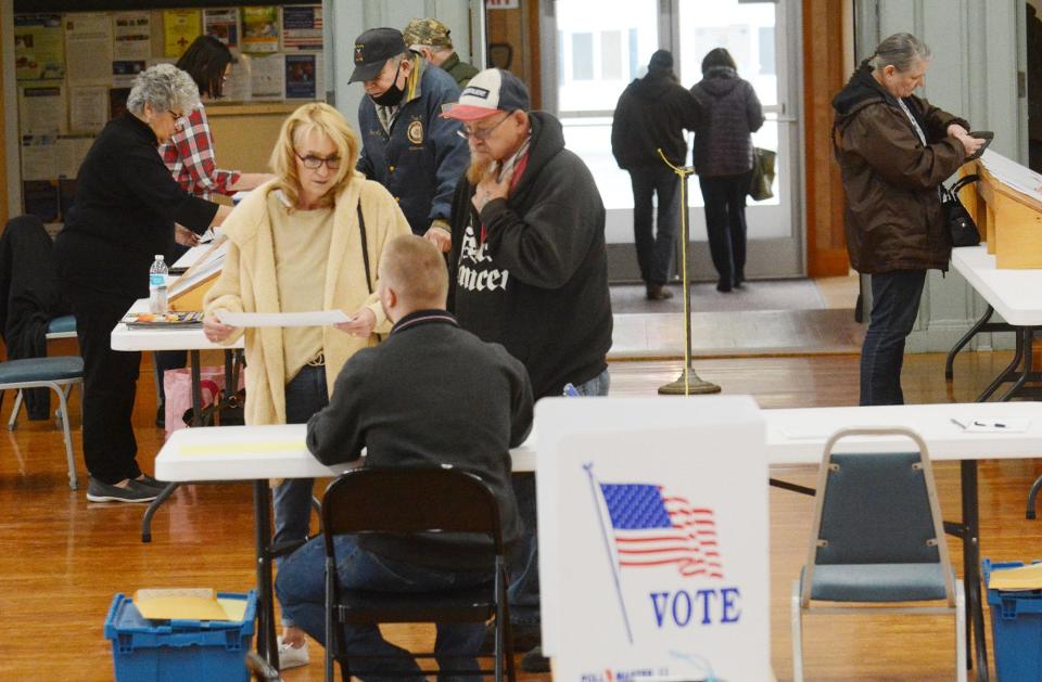 Patricia and Michael Paquette get their ballots before voting at Plainfield Town Hall. File photo