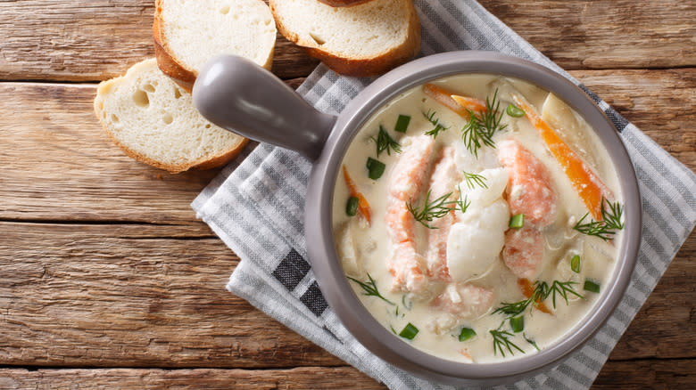 Fish soup in gray bowl on top of striped towel