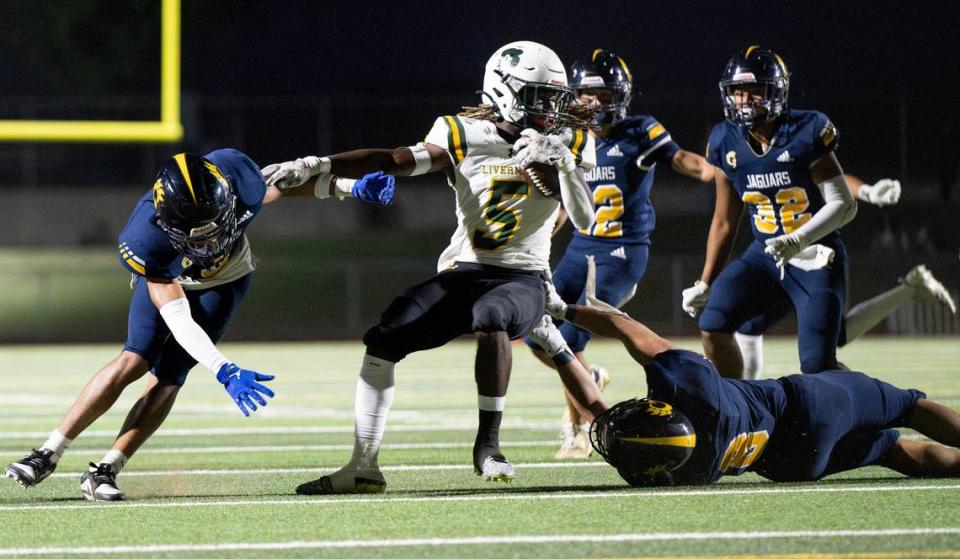 Gregori’s Trey Webb, left, and Lucas Medrano (8) wrap up Livermore running back Kamarri Robinson behind the line of scrimmage during the nonleague game at Gregori High School in Modesto, Calif., Friday, September 8, 2023. Gregori won the game 41-17.