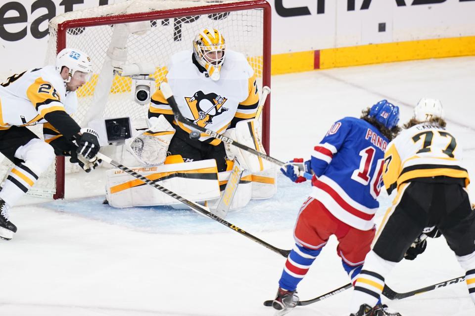 Pittsburgh Penguins goaltender Louis Domingue (70) stops a shot on goal by New York Rangers' Artemi Panarin (10) during the second period of Game 5 of an NHL hockey Stanley Cup first-round playoff series Wednesday, May 11, 2022, in New York. (AP Photo/Frank Franklin II)