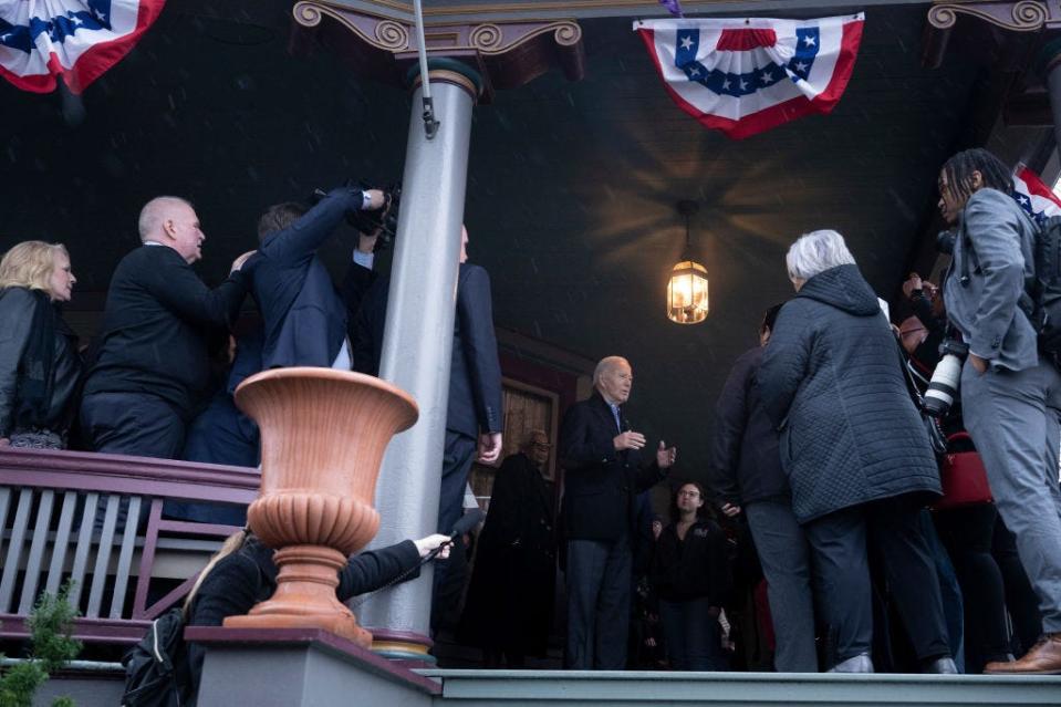 US President Joe Biden, center speaks with supporters at a campaign event outside a private home in the Cathedral District neighborhood of Saginaw, Mich., on March 14, 2024.