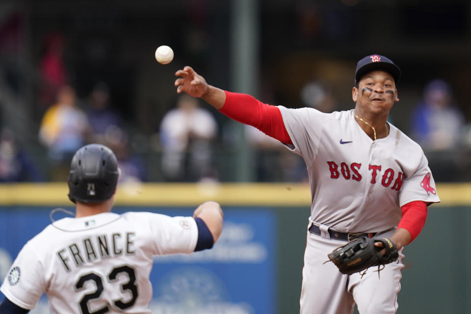 Boston Red Sox third baseman Rafael Devers throws to first base after forcing out Seattle Mariners' Ty France at second in the sixth inning of a baseball game Wednesday, Sept. 15, 2021, in Seattle. Mariners' Abraham Toro was out at first on the double play. (AP Photo/Elaine Thompson)