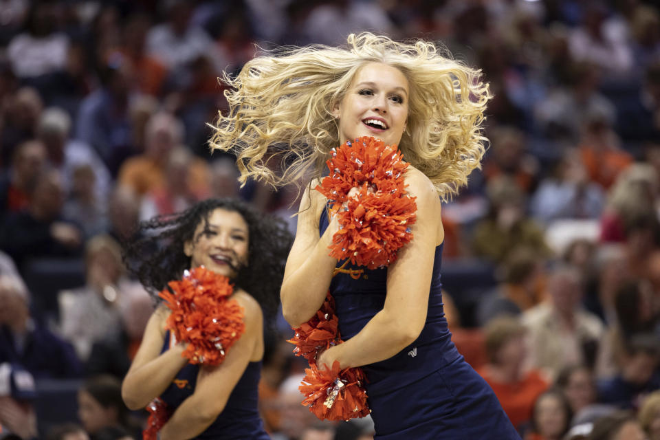 A Virginia cheerleader dances during the first half of an NCAA college basketball game against Louisville in Charlottesville, Va., Saturday, March 4, 2023. (AP Photo/Mike Kropf)