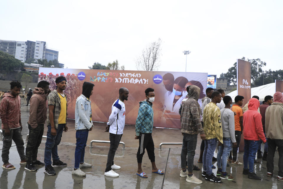 People joining the Defense Forces queue, at Meskel Square, in Addis Ababa, Ethiopia, Tuesday, July 27 2021. A repatriation program is underway for young people from Ethiopia who have decided to join the Defense Forces. (AP Photo)