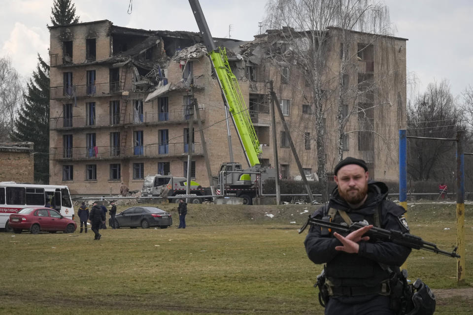 A police officer gestures to prevent photographing at the scene of a drone attack in the town of Rzhyshchiv, Kyiv region, Ukraine, Wednesday, March 22, 2023. (AP Photo/Efrem Lukatsky)
