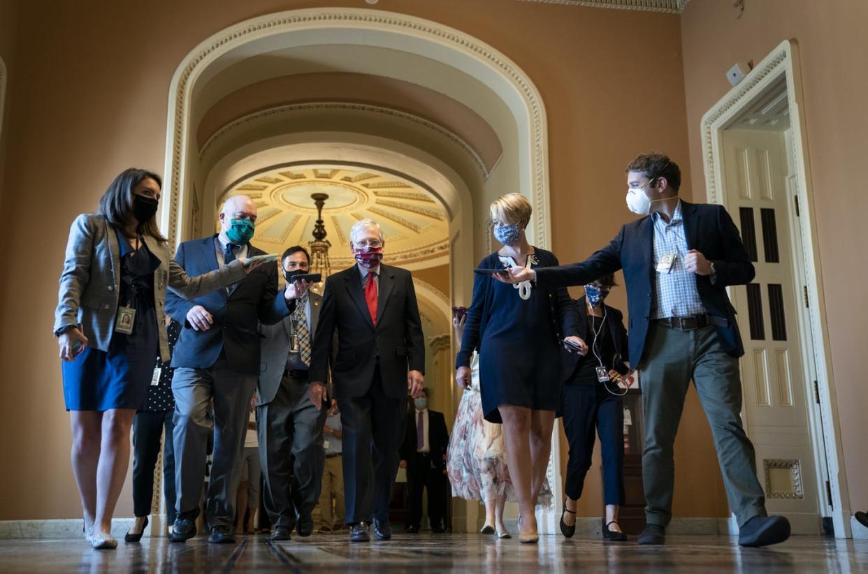 <span class="caption">Senate Majority Leader Mitch McConnell with reporters, July 30, 2020. </span> <span class="attribution"><a class="link " href="https://www.gettyimages.com/detail/news-photo/senate-majority-leader-mitch-mcconnell-is-swarmed-by-news-photo/1227843983?adppopup=true" rel="nofollow noopener" target="_blank" data-ylk="slk:Drew Angerer/Getty Images);elm:context_link;itc:0;sec:content-canvas">Drew Angerer/Getty Images)</a></span>