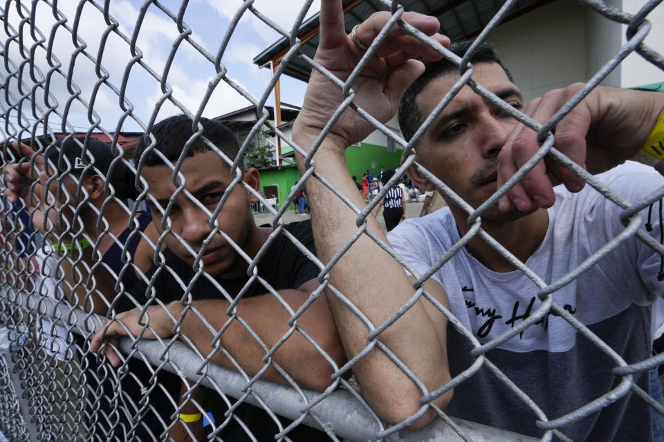 Venezuelan migrants hoping to return to their country of origin, wait to be driven to the international airport, outside a commercial warehouse being used as a temporary shelter, in Panama City, Wednesday, Oct. 26, 2022. (AP Photo/Arnulfo Franco)