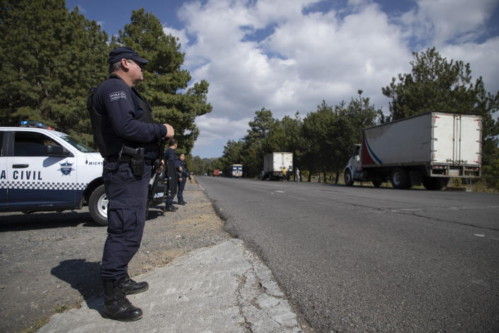 Police guard trucks loaded with avocados on their way to the city of Uruapan in Santa Ana Zirosto, Michoacan state, Mexico, Thursday, Jan. 26, 2023. (AP Photo/Armando Solis)