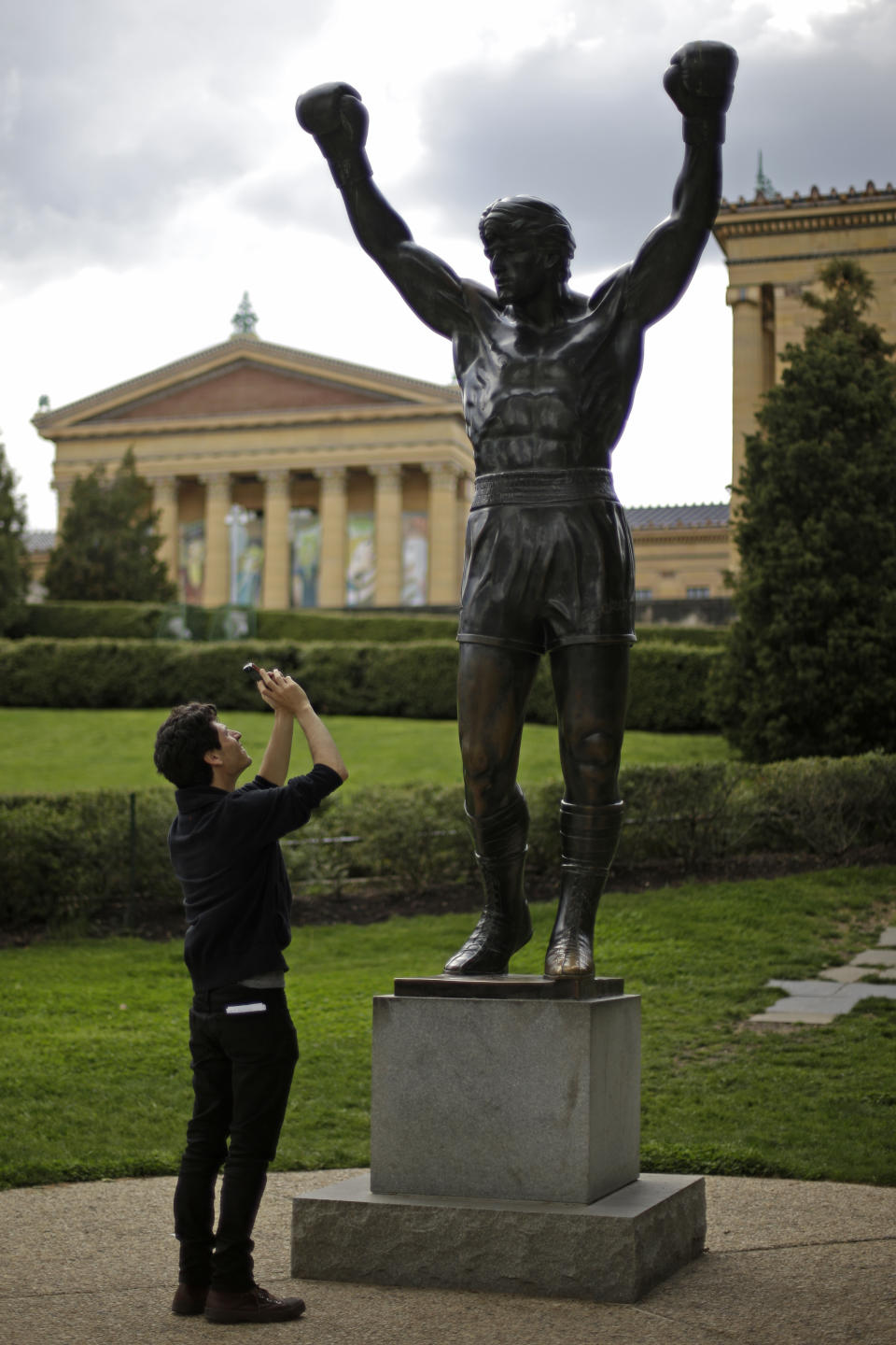 In this Wednesday, May 8, 2013 photo a tourist photographs a bronze Rocky statue outside the Philadelphia Museum in Philadelphia. The City of Brotherly Love is perhaps best known for its Colonial roots but locals will tell you there's much more to explore in this city of 1.5 million people. (AP Photo/Matt Rourke, File)