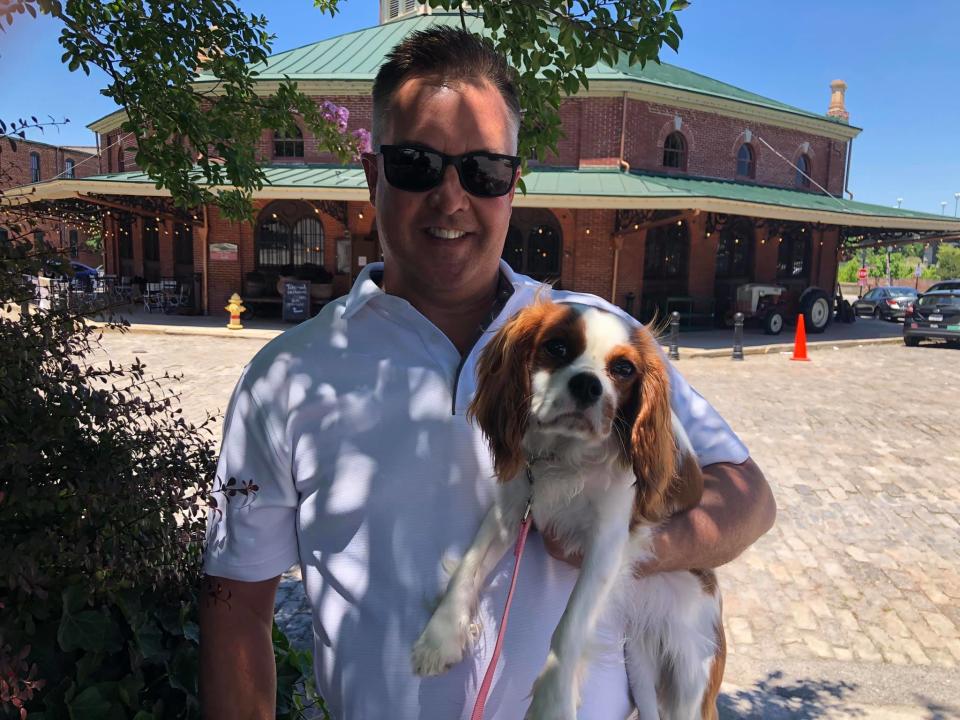 Tim Seaton of Chesterfield strikes a pose with his Cavalier King Charles Spaniel Maggie in front of the iconic Farmers Market building in Petersburg.