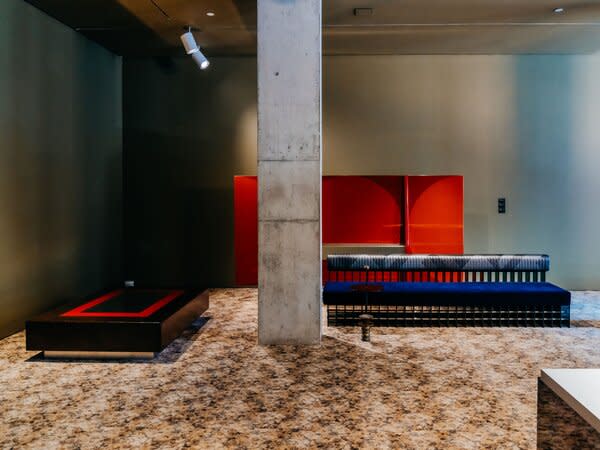 A coffee table, a bench, and a giant lacquered screen that is both art and function creates a hushed tableau. The coffee table is made of recycled cork, and the bench, velvet, smoked glass, and pure sex appeal.